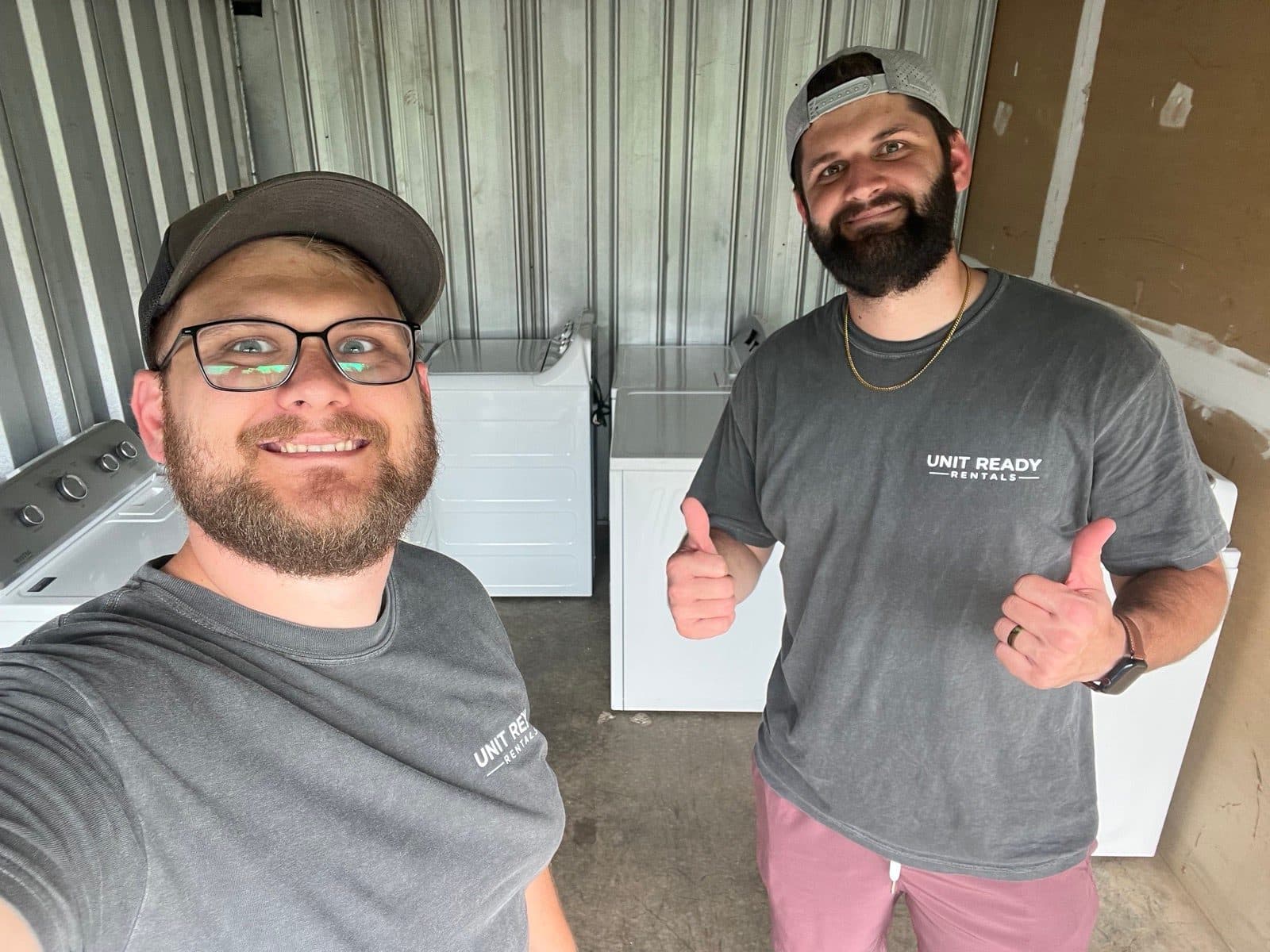 The UnitReady Rentals owners — two local brothers — with a washer and dryer set